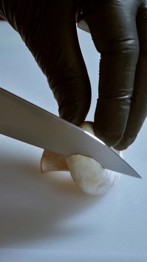 Vertical video, slow motion. Chef cut mushrooms into slices on a kichen board. Stock Footage 297250062