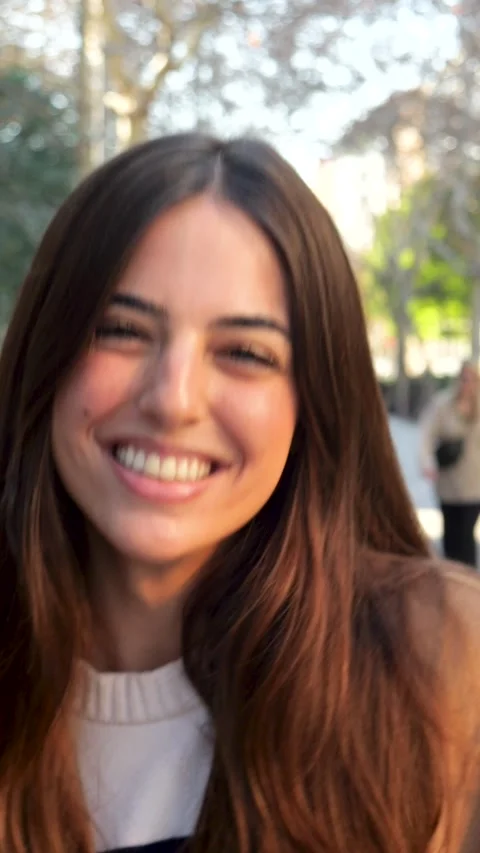 Vertical video. Slow motion of a smiling carefree young woman walking in a city Stock Footage 264277039