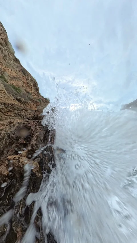 Vertical video. A slow-motion view of water exploding upward from a wave Stock Footage 293742614