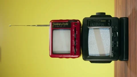 Vertical video of small old televisions with grey interference screen on yellow Stock Footage 172270191