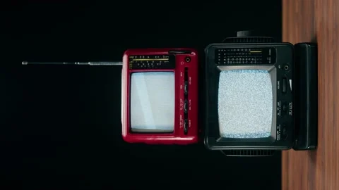 Vertical video of small old televisions with grey interference screen on black Stock Footage 172270782