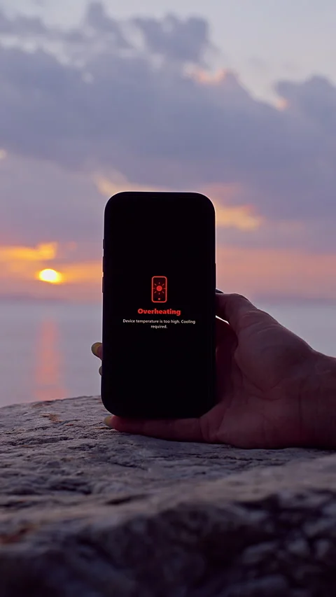Vertical video. Smartphone Displaying Overheating Warning While Held Above Coast Stock Footage 339195795
