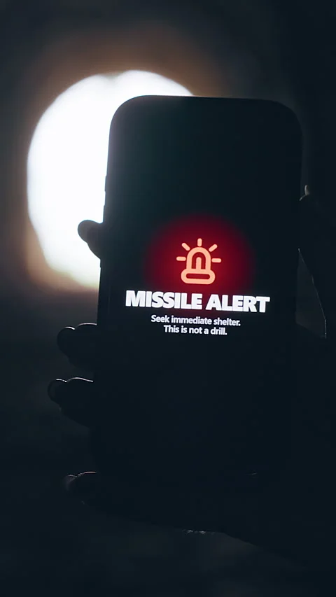 Vertical video. Smartphone Screen Showing Missile Attack Alert Inside Dark Tunne Stock Footage 335222934