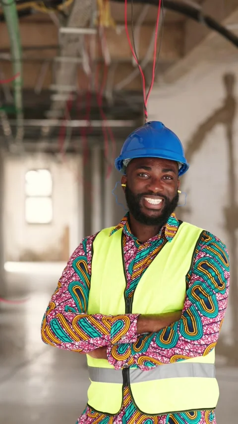 Vertical Video Smiling African construction engineer in blue hard hat on site  Stock Footage 347379210