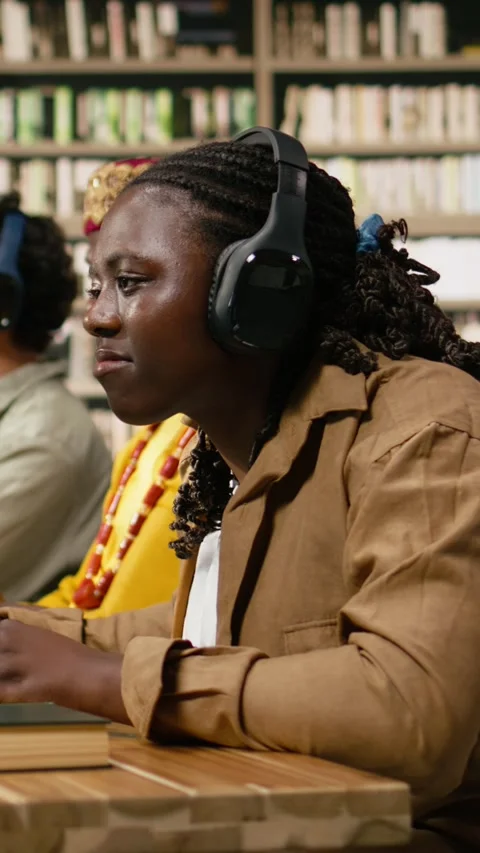 Vertical Video Smiling black student wearing headphones and typing at desktop Stock Footage 337529041