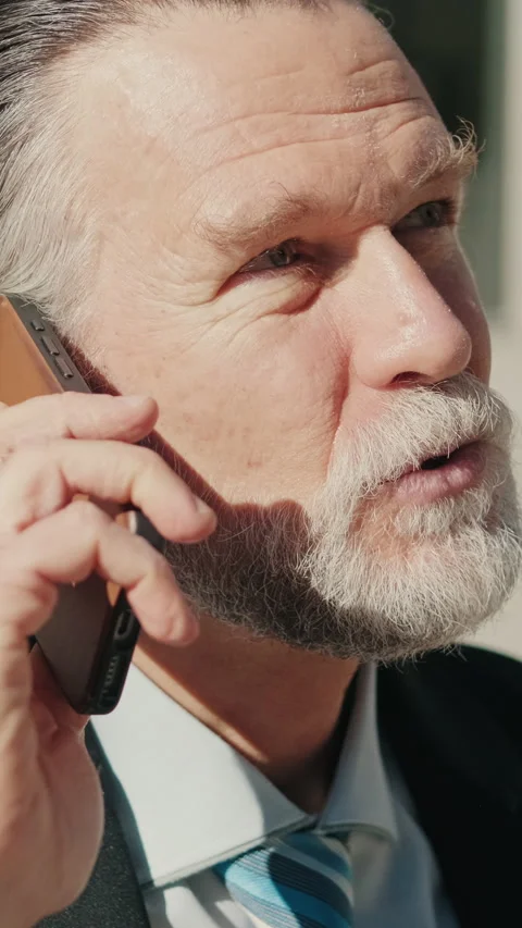 Vertical video, Smiling Businessman Talking on Phone Outdoors Stock Footage 303777564