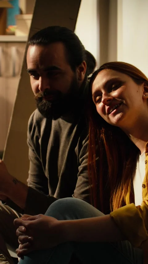 Vertical Video Smiling couple takes break from unpacking furniture and personal Stock Footage 343349405