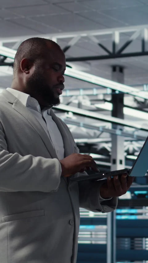 Vertical video Smiling data center technician installing and upgrading hardware Stock Footage 311341429