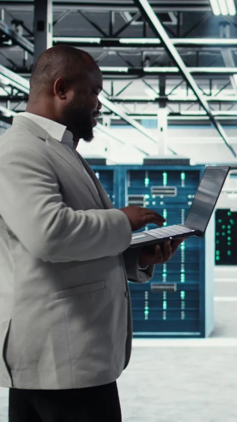 Vertical video Smiling data center programmer using laptop to upgrade system Stock-Footage 311489736