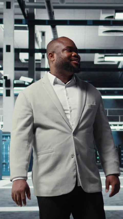 Vertical video Smiling engineer walking in data center, checking hardware for Stock Footage 311489809