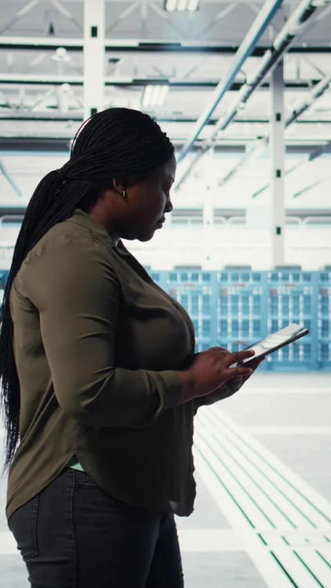 Vertical video Smiling engineer walking in data center with laptop, checking Video stock 316863547