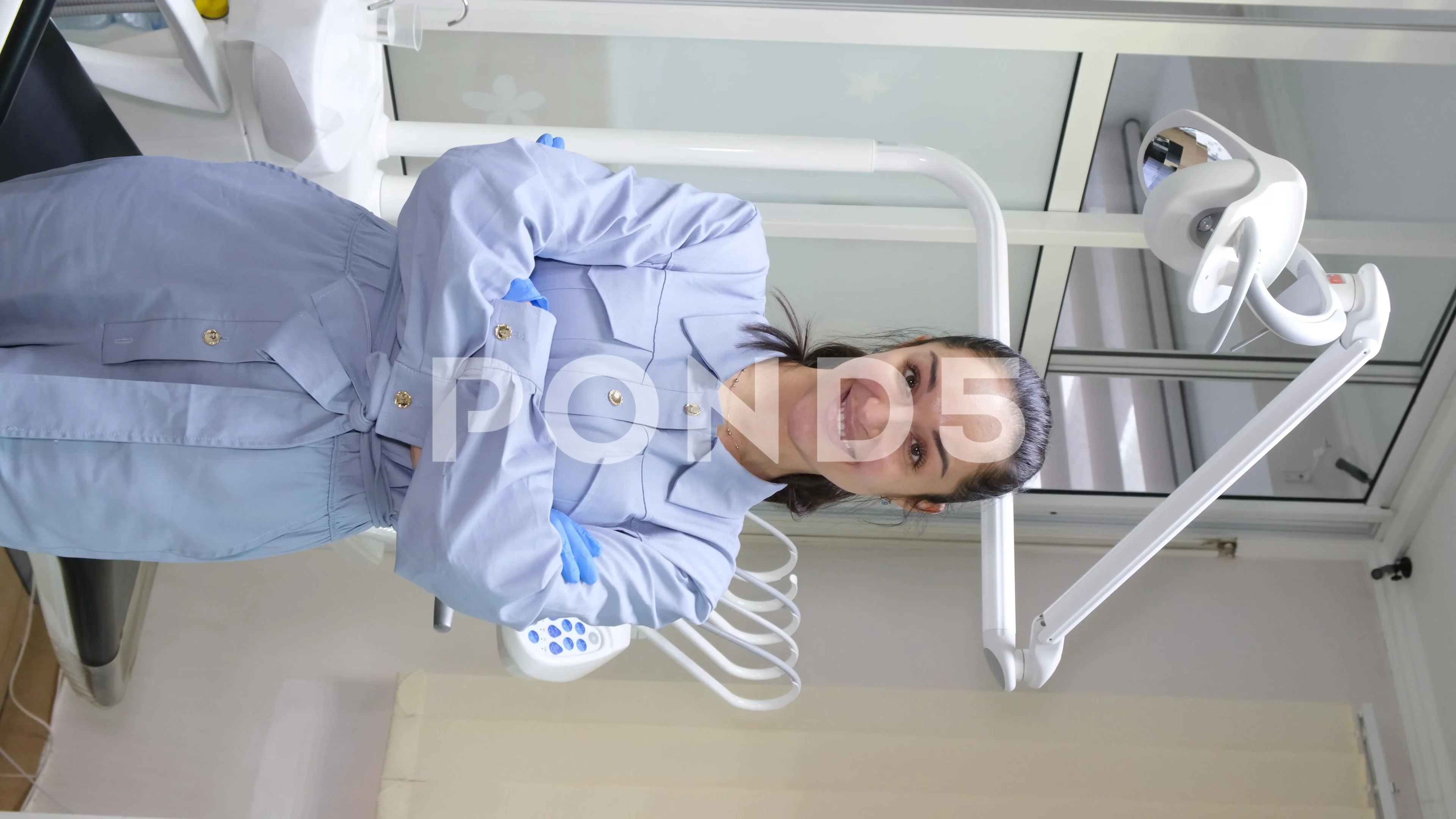 Vertical video of a smiling female dentist. Modern dental clinic. Dental