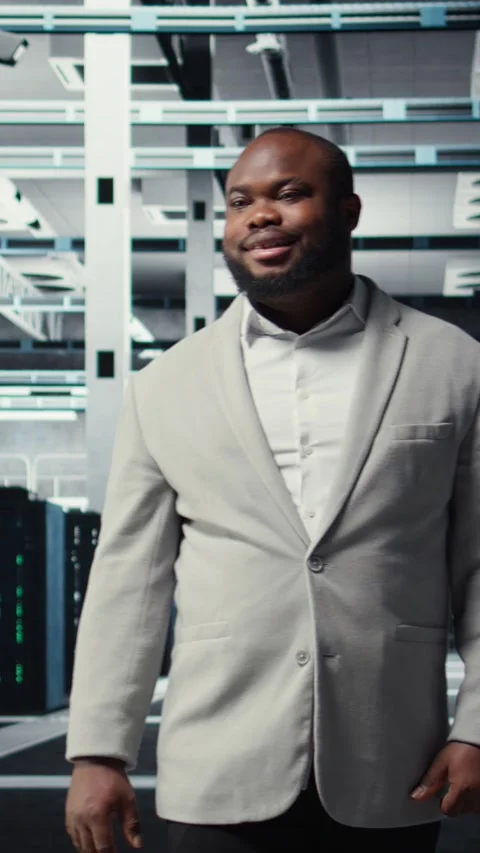 Vertical video Smiling manager in data center doing checkup on hardware to avoid Stock Footage 311489387