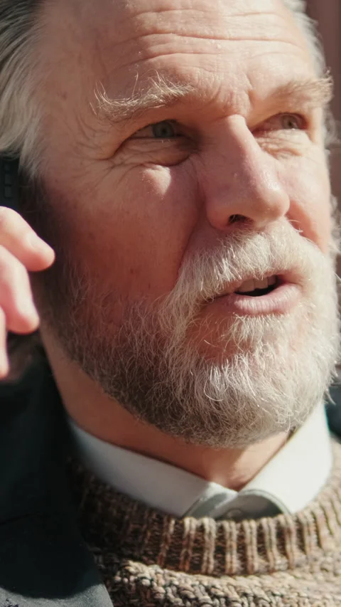 Vertical video, Smiling Older Man Talks On Phone Outdoors Stock Footage 309403543