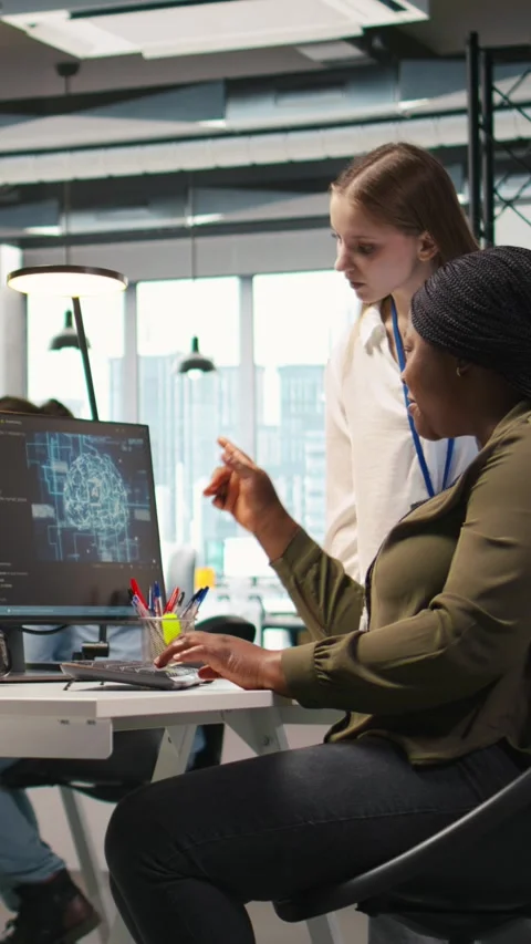Vertical video Smiling startup manager teaching junior dev how to use machine Stock Footage 312768553