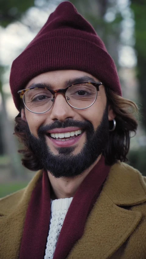 Vertical video of smiling young Caucasian man with winter hat looking camera Stock Footage 229862358