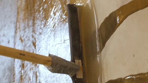 Vertical video. Smoothing the primer on the concrete floor with a trowel. Stock-Footage 268185463