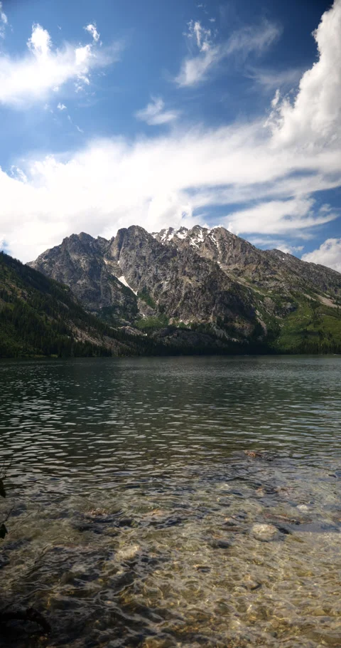 Vertical video of snow-capped mountain peaks beside a peaceful alpine lake Stock-Footage 341433336