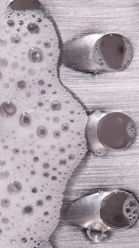 Vertical video. Soap Foam Spreading Across Metal Grater Surface with Water Flow, Stock Footage 334237414