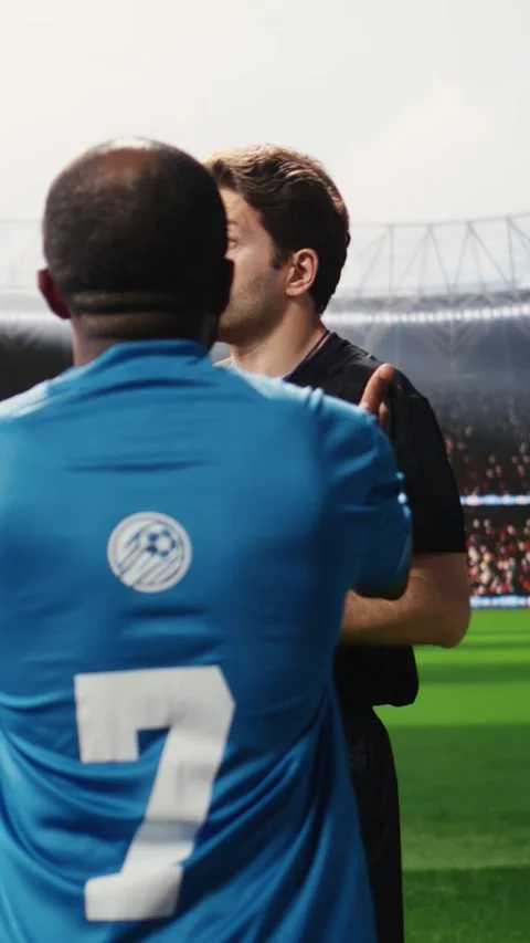 Vertical Video Soccer referee in black showing yellow card to protesting player Stock Footage 338046926