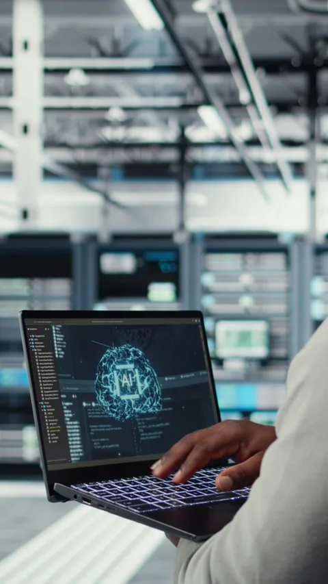 Vertical video Software developer in data center uses AI technology on laptop Stock Footage 311415252