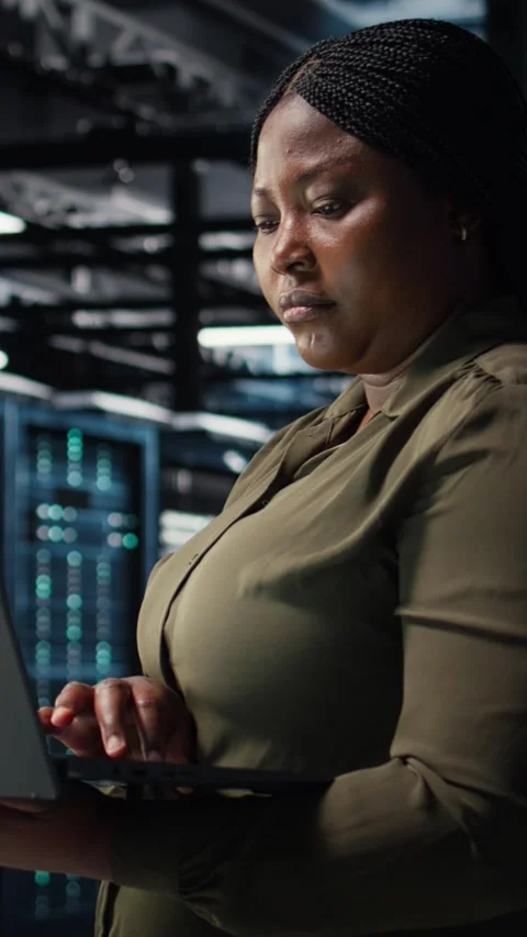 Vertical video Software developer in data center using laptop to upgrade systems Stockbeeldmateriaal 317053743