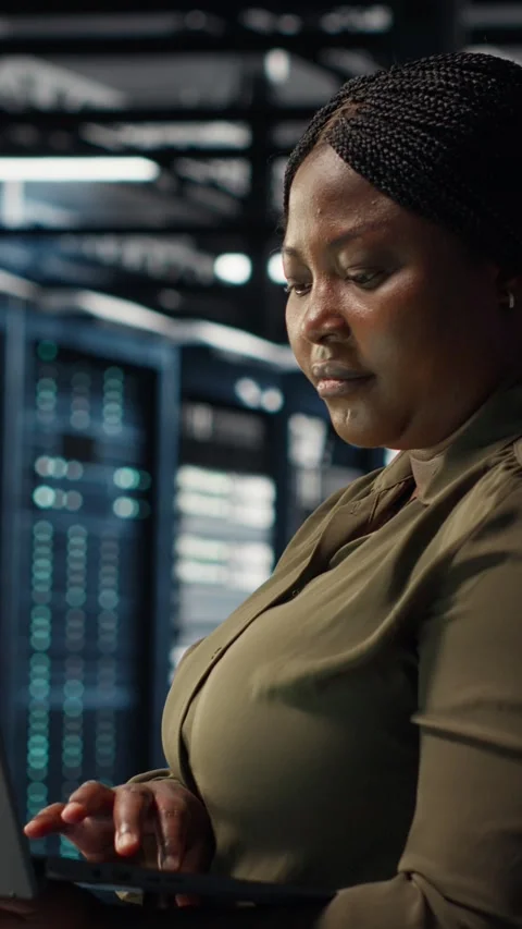 Vertical video Software developer in data center using laptop to upgrade systems Stock Footage 317054678