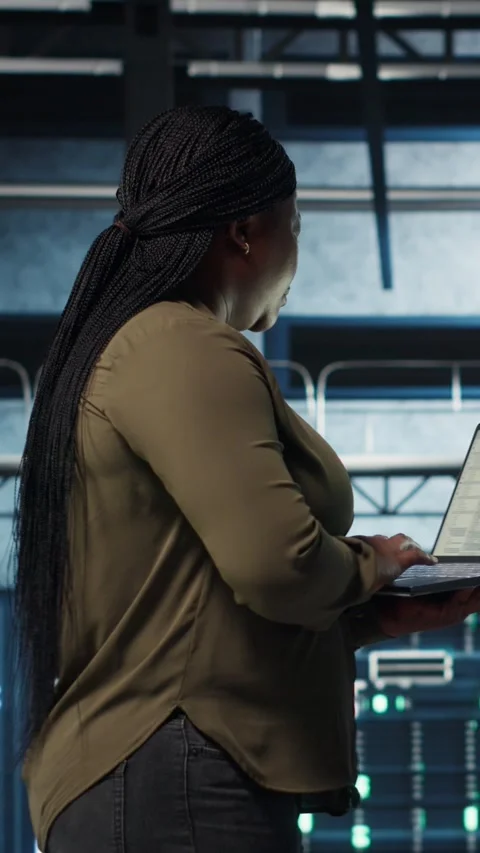 Vertical video Software developer in data center using laptop to deploy new Stock Footage 317056015