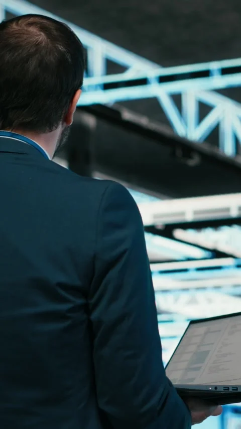 Vertical video Software developer in data center using laptop to code Stock Footage 329943639