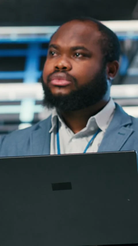 Vertical video Software developer in server farm using laptop, doing network Stock Footage 330138353