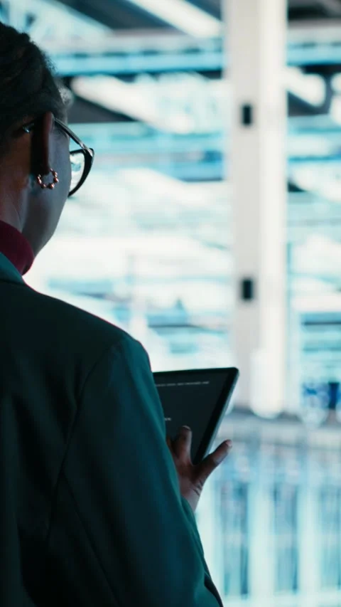 Vertical video Software developer walks in data center, using tablet and AR 動画素材 329650182
