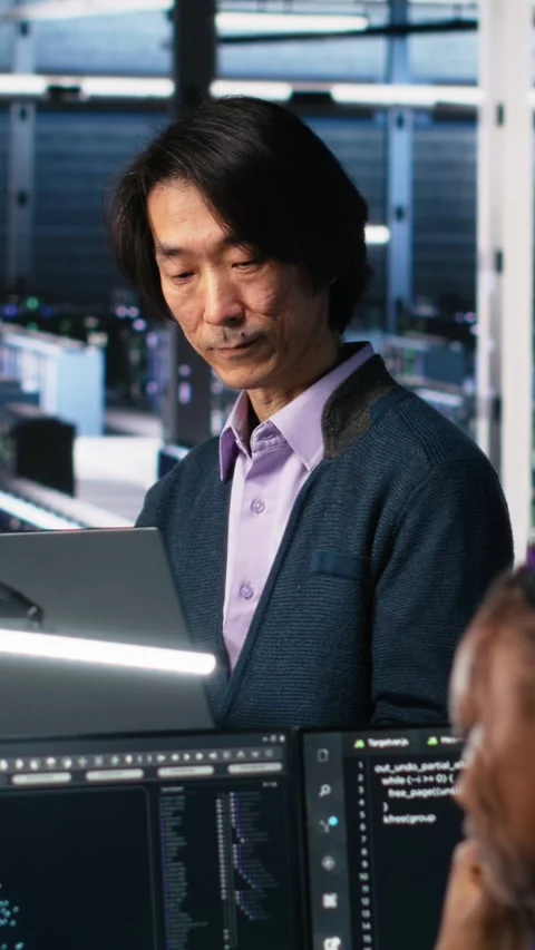 Vertical video Software developers cooperating in data center, reviewing AI Stock Footage 313507665
