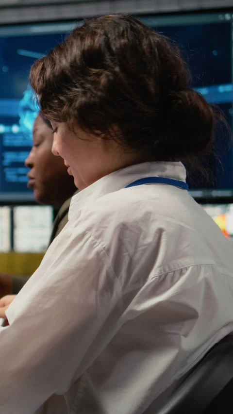 Vertical video Software developers in startup office brainstorming leveraging AI Stock Footage 322695814