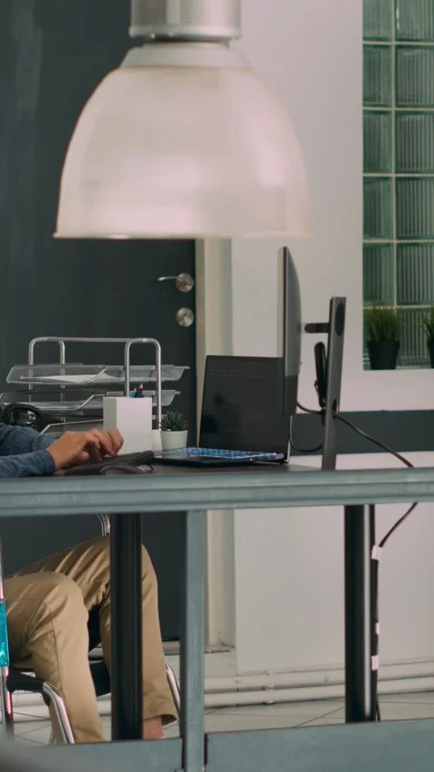 Vertical video: Software programer with physical disability writing code on Stock Footage 218575245