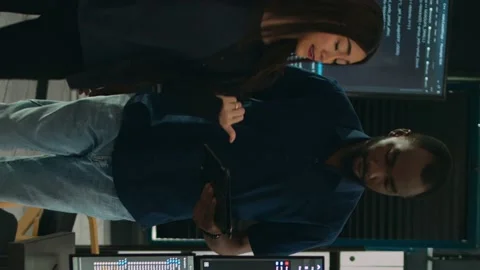 Vertical video: Software programmers talking about algorithms on big screen and 動画素材 219701926