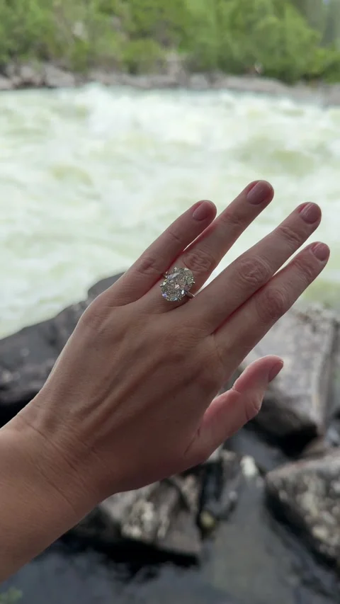 Vertical video of solitaire ring hand extended over river waterfall Stock Footage 317728169