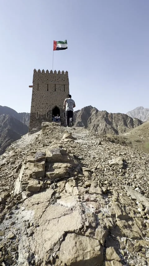 Vertical Video: Solo Content Creator Running On Mountain Peak With UAE Watchtowe Stock Footage 342581561