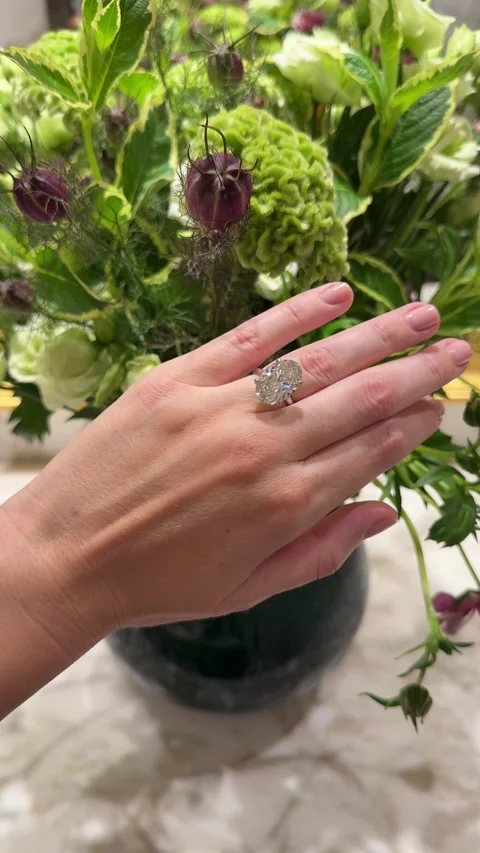 Vertical video of sparkling oval diamond engagement ring near flowers Stock Footage 317336829