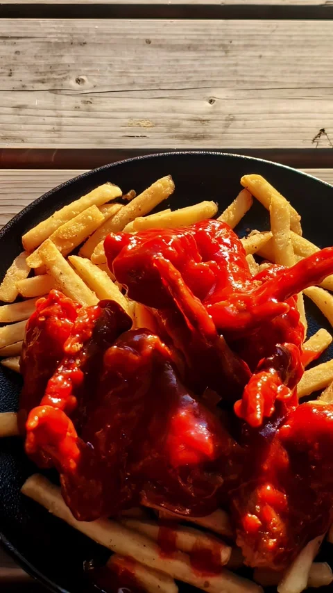 Vertical Video - Spicy Chicken Wings and Fries on Wooden Table, Close Up Stock Footage 337929176