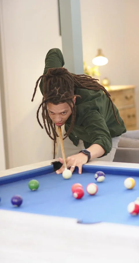Vertical video: Spotting break, man with dreadlocks lining cue on pool table in Stock Footage 345129325