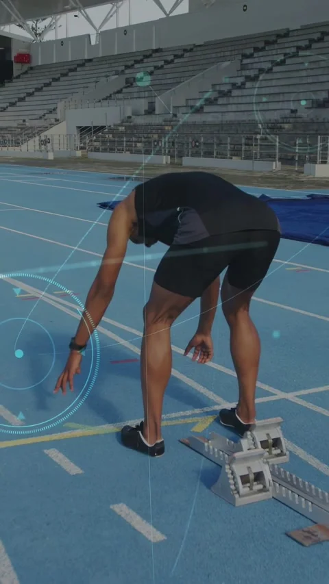 Vertical video: Sprinter in sport approaching blocks, taking crouch start with Stock Footage 332869220