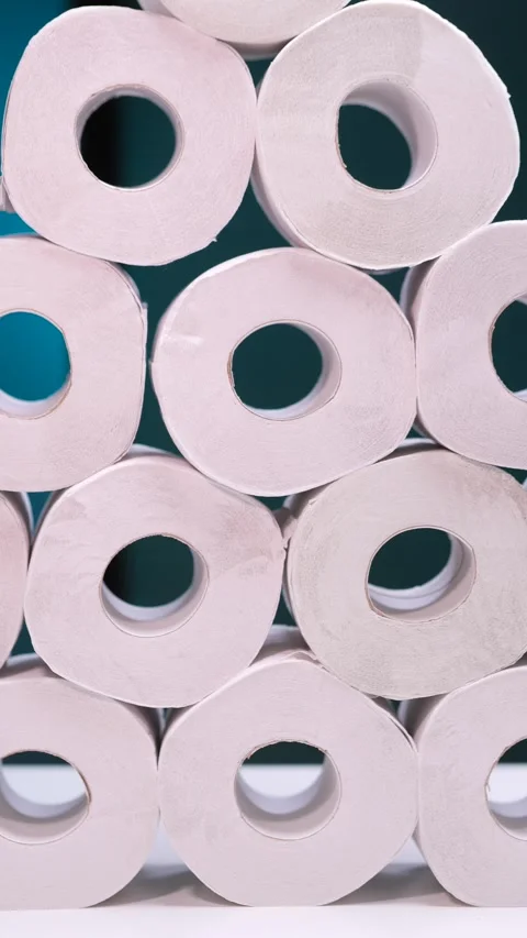 Vertical video Stack of toilet paper rolls forming a pyramid on a white surface Stock Footage 302224860