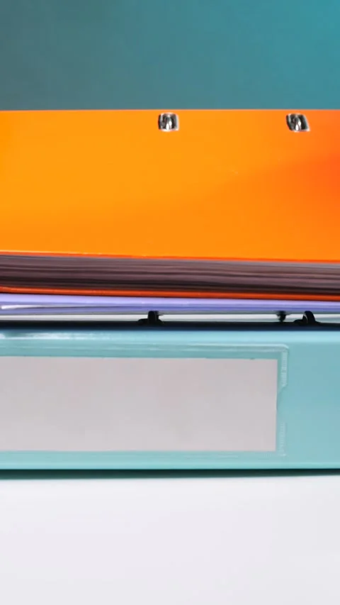 Vertical video stacked ring binders showcasing organized paperwork and Stock Footage 342770966