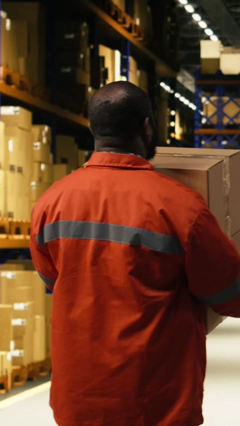Vertical Video Stacking cargo pallets, black warehouse worker, in distribution Stock Footage 333090567