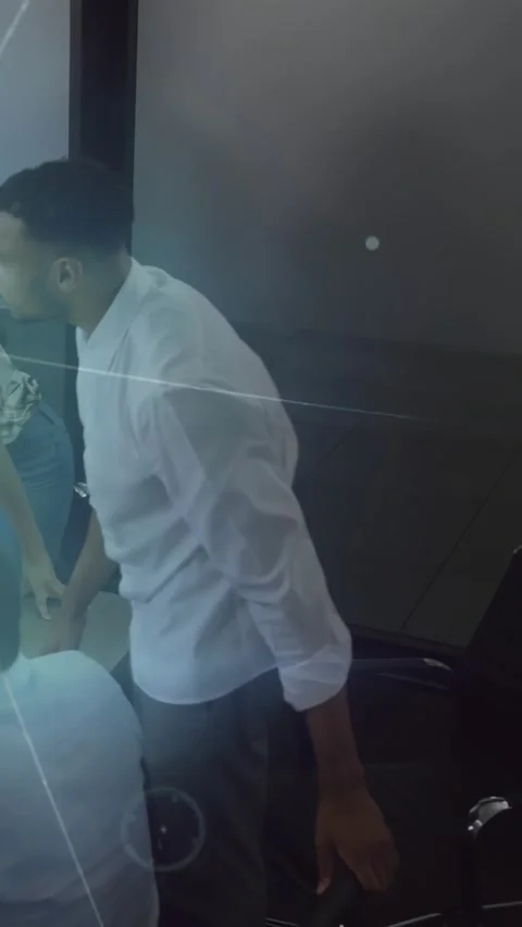 Vertical video: Standing man leaning on chair, reviewing tech display as HUD Stock Footage 331047321