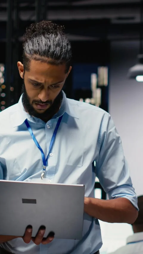Vertical Video Standing in office, arab manager holds laptop, evaluating Stock Footage 334105460
