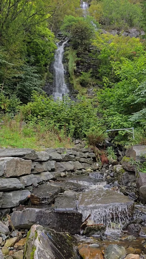Vertical video of Starefossen waterfall cascading down green mountain in Bergen Stock Footage 345168190