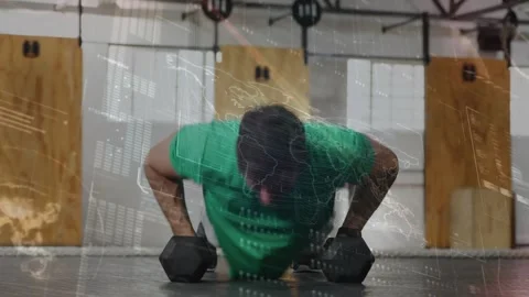 Vertical video: Starting man green tee doing pushups and DB rows on gym floor Stock Footage 330741674