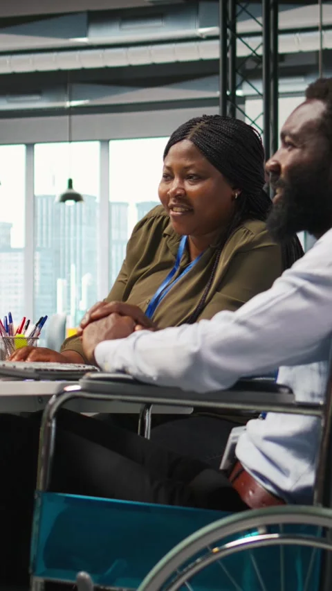 Vertical video Startup office programmer in wheelchair talking with colleague Stock Footage 312769065