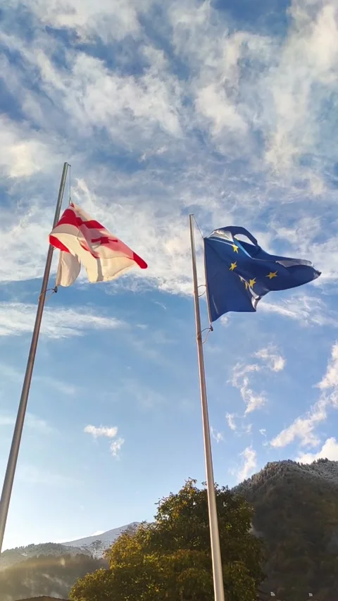 Vertical video state flags of Georgia and European union waving in wind towards Stock Footage 266739486
